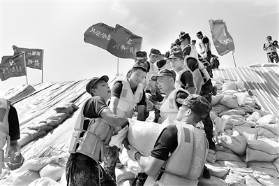 7月以來，江西多地連降暴雨，九江、上饒、南昌等地遭受嚴重洪澇災害。危急關頭，武警江西總隊聞“汛”而動，迅速組織官兵全力投入抗洪搶險戰(zhàn)斗。圖為官兵在九江彭澤縣芙蓉墩圩堤搬運沙袋。新華社發(fā)（洪水平 攝）