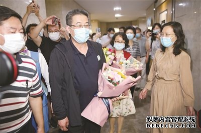 新冠肺炎疫情暴發(fā)后，中央指導組專家組成員，東南大學附屬中大醫(yī)院黨委副書記、紀委書記、主任醫(yī)師邱海波四度出征，先后轉戰(zhàn)湖北、黑龍江、吉林、新疆等地，在抗疫一線鏖戰(zhàn)185天。圖為6月5日，邱海波從吉林返回南京，在機場受到熱烈歡迎。（圖片來源：視覺中國）
