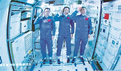圖為6月17日在北京航天飛行控制中心拍攝的進(jìn)駐天和核心艙的航天員向全國人民敬禮致意的畫面。 新華社記者 金立旺 攝