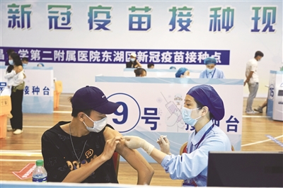 近日，在江西省體育館方艙接種點(diǎn)，南昌大學(xué)第二附屬醫(yī)院的醫(yī)護(hù)人員在給大學(xué)生接種新冠疫苗。新華社記者 萬象 攝