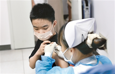 近日，海南省?？谑屑涌焱七M(jìn)12至17周歲人群新冠疫苗接種工作。圖為8月4日，在?？谑腥嗣襻t(yī)院新冠病毒疫苗接種點(diǎn)，醫(yī)護(hù)人員在為接種者接種疫苗。 新華社記者 楊冠宇 攝