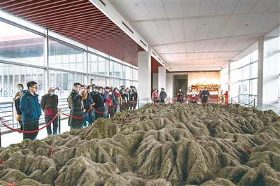 圖為游客在井岡山革命博物館參觀，聽解說(shuō)員講解井岡山斗爭(zhēng)地形圖。正是在這樣崎嶇蜿蜒的山地環(huán)境中，井岡山革命根據(jù)地不斷擴(kuò)大，點(diǎn)燃了工農(nóng)武裝割據(jù)的星星之火，為中國(guó)革命探索出農(nóng)村包圍城市、武裝奪取政權(quán)的正確道路。（圖片來(lái)源：視覺(jué)中國(guó)）